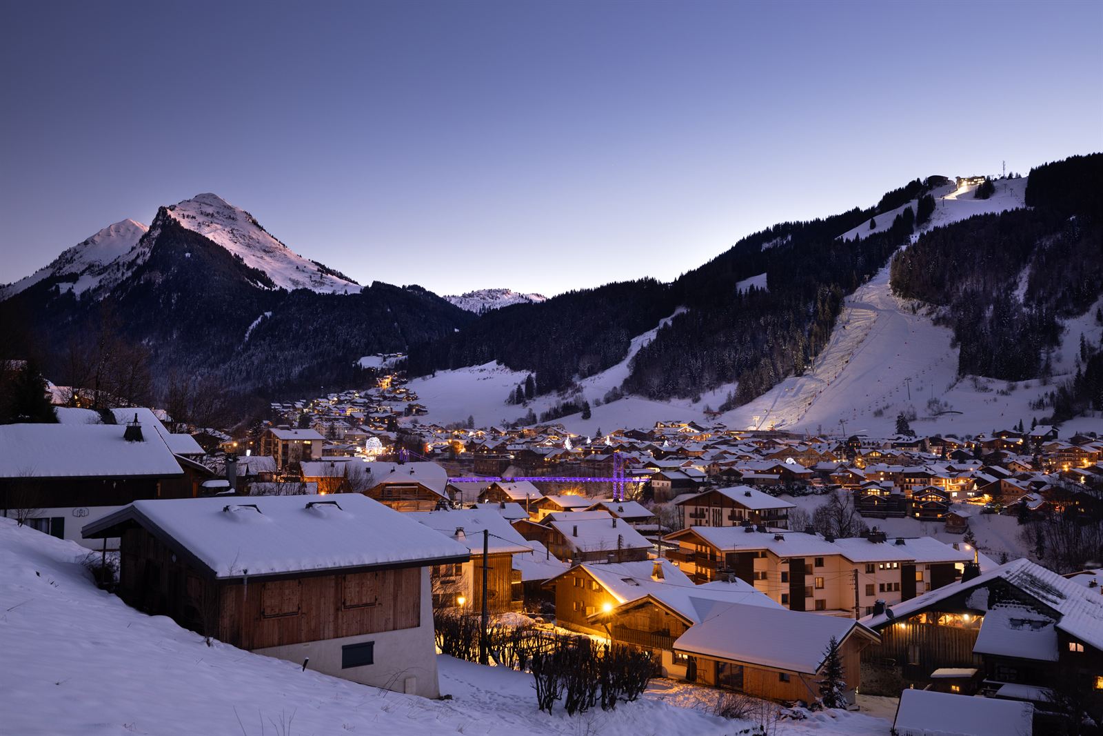 Morzine au crépuscule en hiver, village illuminé sous la Pointe de Nyon